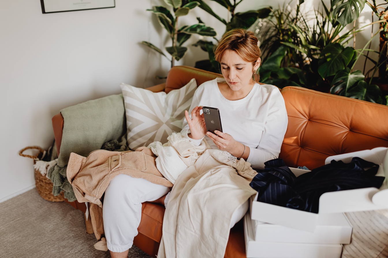 Woman Sitting on a Couch and Using Phone 